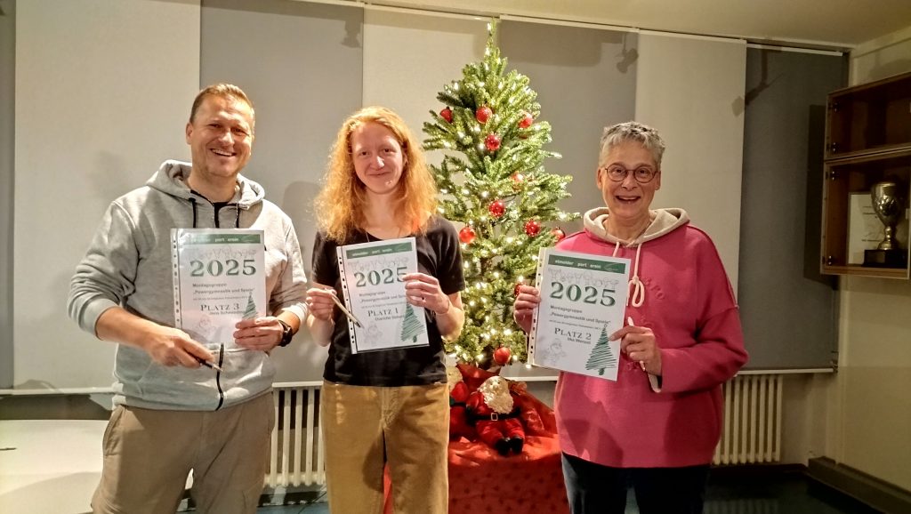 Drei Personen stehen vor einem weihnachtlich geschmückten Tannenbaum und halten Urkunden mit der Aufschrift ‘2025’ und ‘Platz 2’ in den Händen.